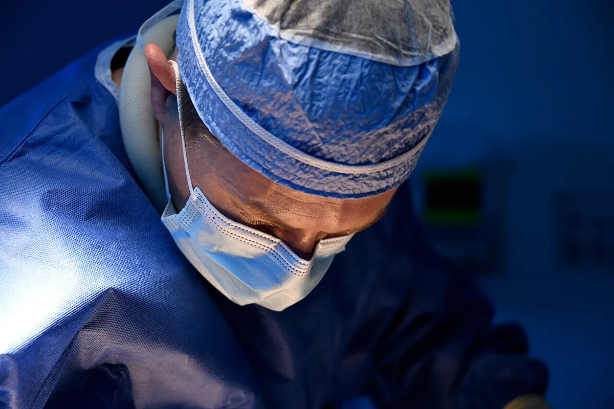 Plastic surgeon operating in a surgical theatre