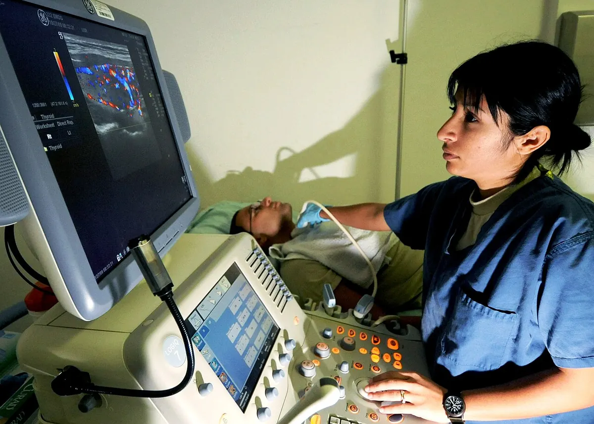Sonographer performing a thyroid ultrasound scan